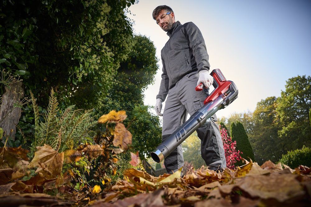 Person bläst Laub mit Laubbläser
